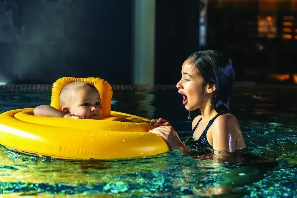 Two children playing with a float ring in the shallow kids pool