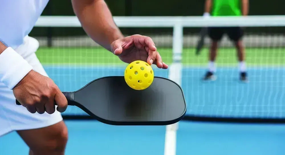 Player serving on the blue pickleball court